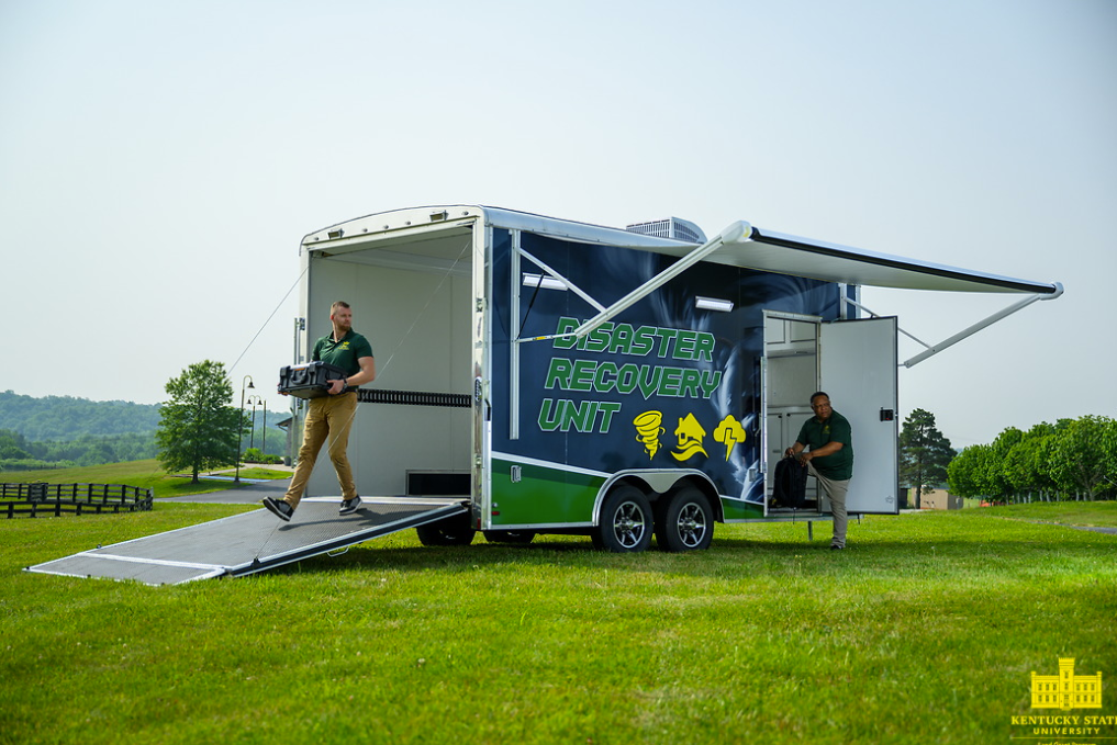 Gill Finley and Cameron Sellers unload Kentucky State University's Disaster Recovery Unit.