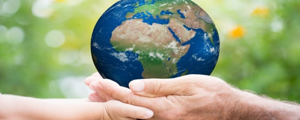 Adult and child hands holding an earth globe