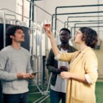 Women and two men looking at product from the Fermentation & Distillation Process