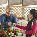 Food Systems - Women buying vegs from man at farmers market