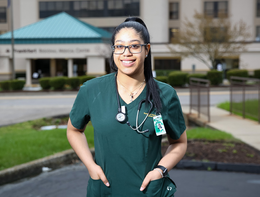 RN to BSN KSU graduate wearing green scrubs