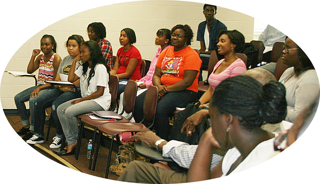 Concert Choir students sitting in a room listening to a speaker.