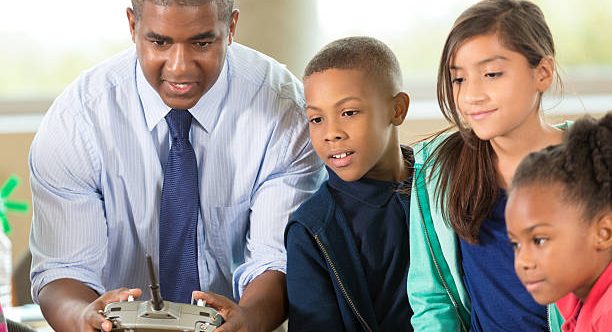 Man with three children working a remote